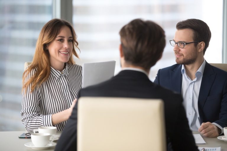 female and male recruiter discussing in front of a male job applicant