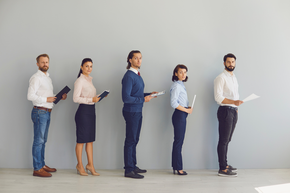 Job candidates with resumes queuing up waiting for interview