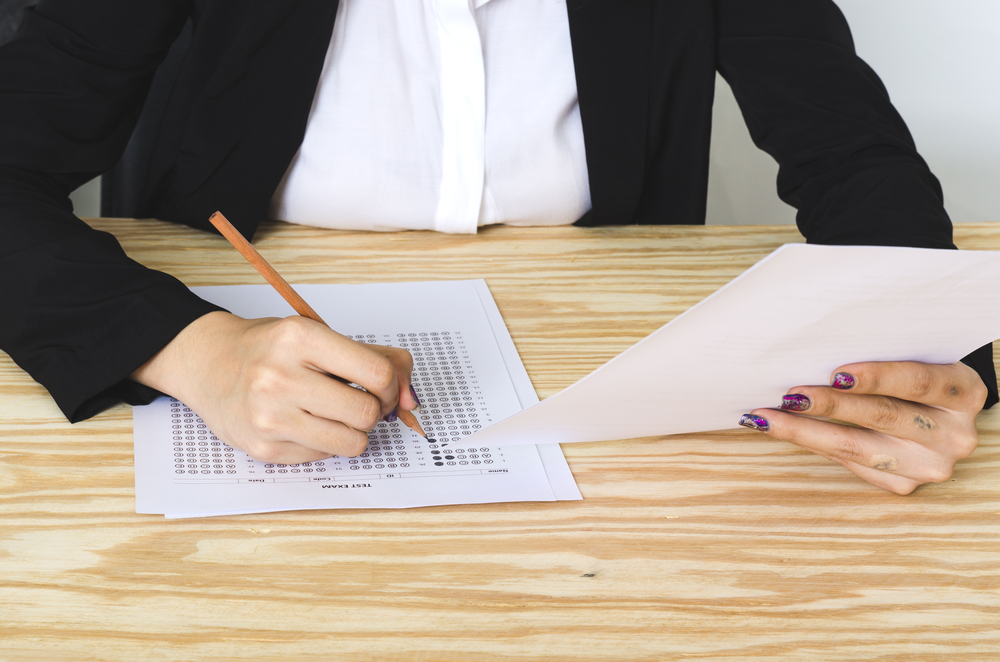 women job applicant answering a test on the wooden table