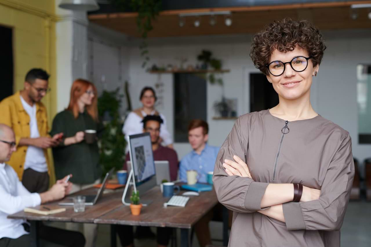 woman wearing eyeglasses standing in front of meeting