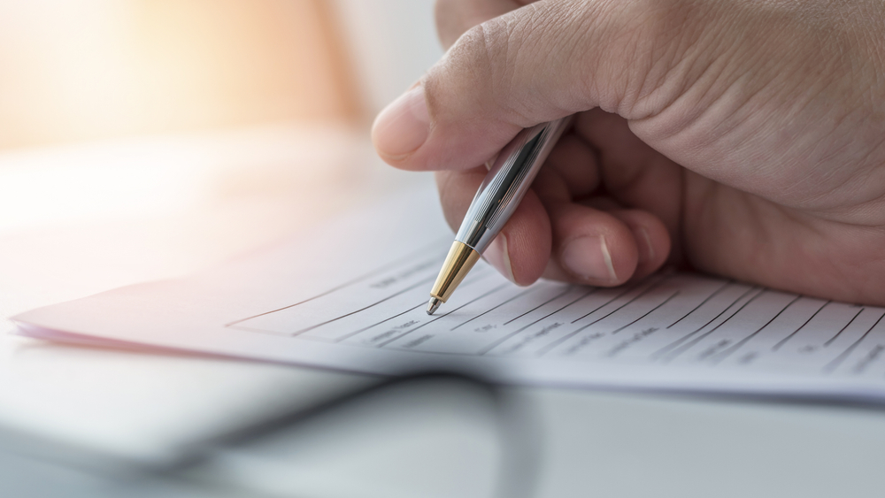 close up of a hand filling up application form