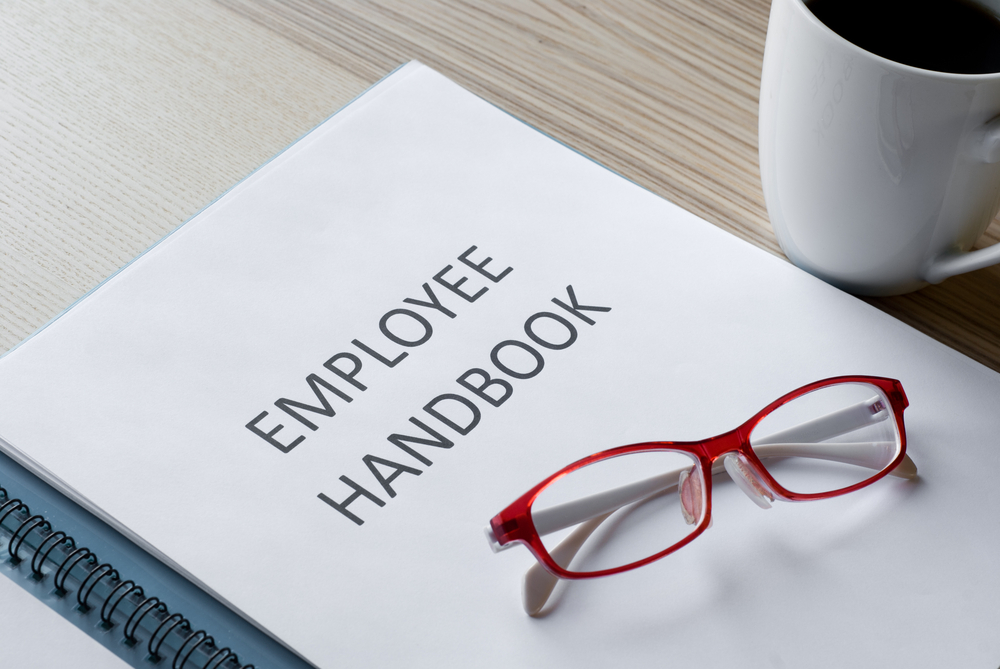 employee handbook with eyeglasses on top