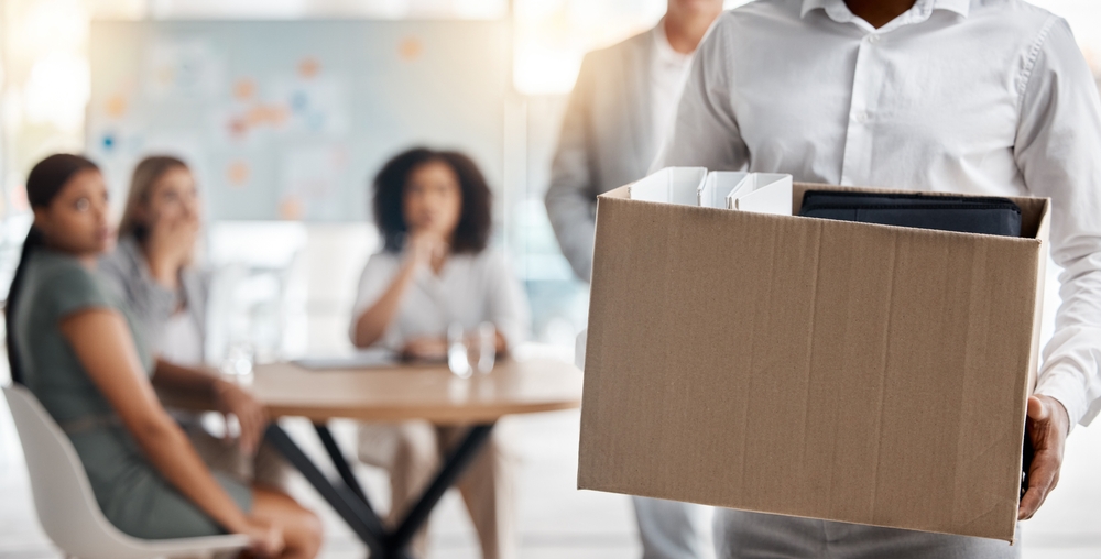 employee holding box with stuff as he exits the company