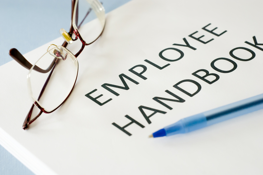 employee handbook with glasses on top of it