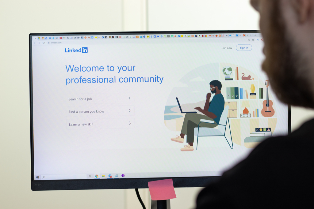 man looking at the LinkedIn website page in his computer