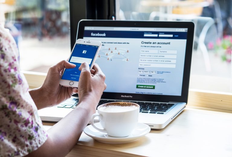 woman logging in her Facebook account using a mobile phone