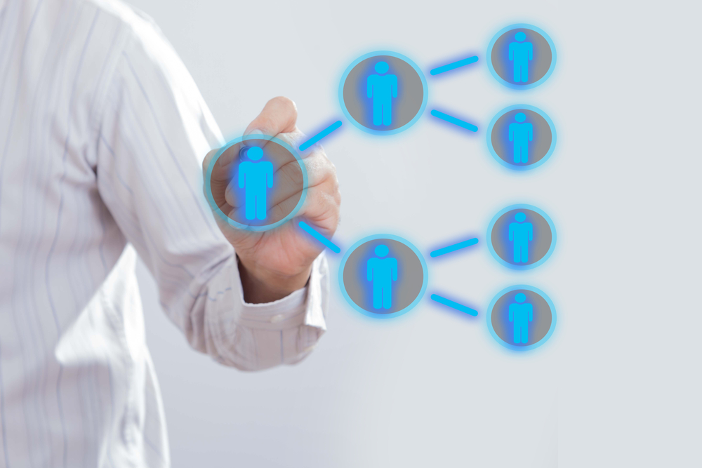 a man drawing a referral matrix on transparent board