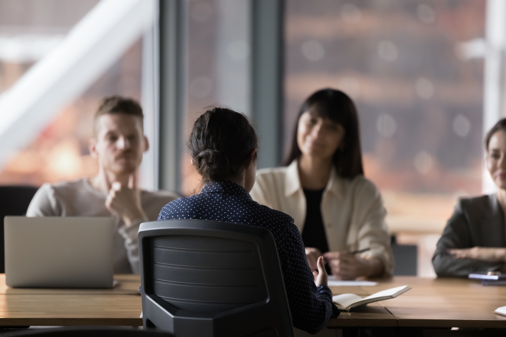 backview of female applicant being interviewed with company management