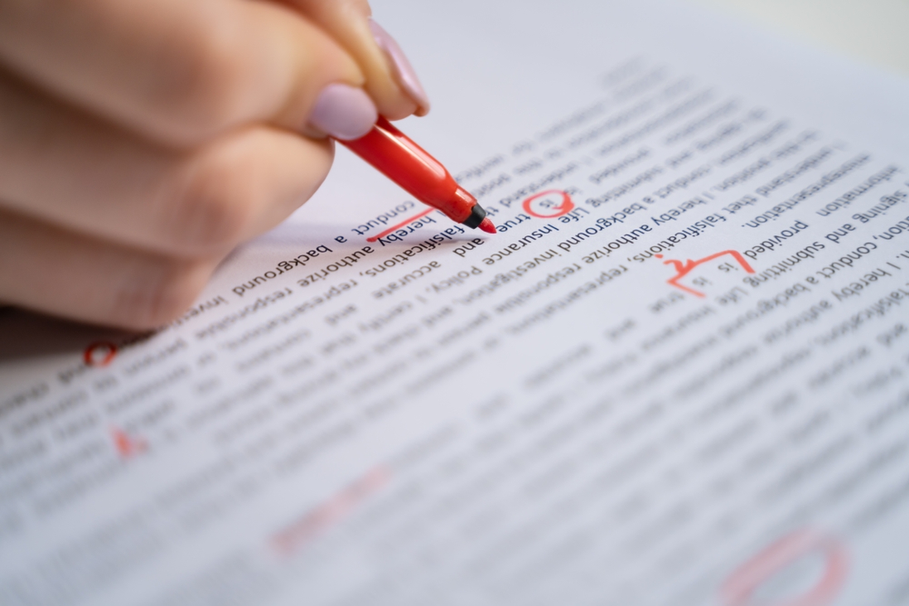 close up shot of a hand marking wrong spelling and grammar on paper