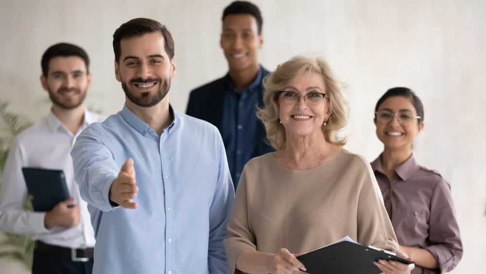 a male recruiter extending arm for handshake with company managers on hiring process