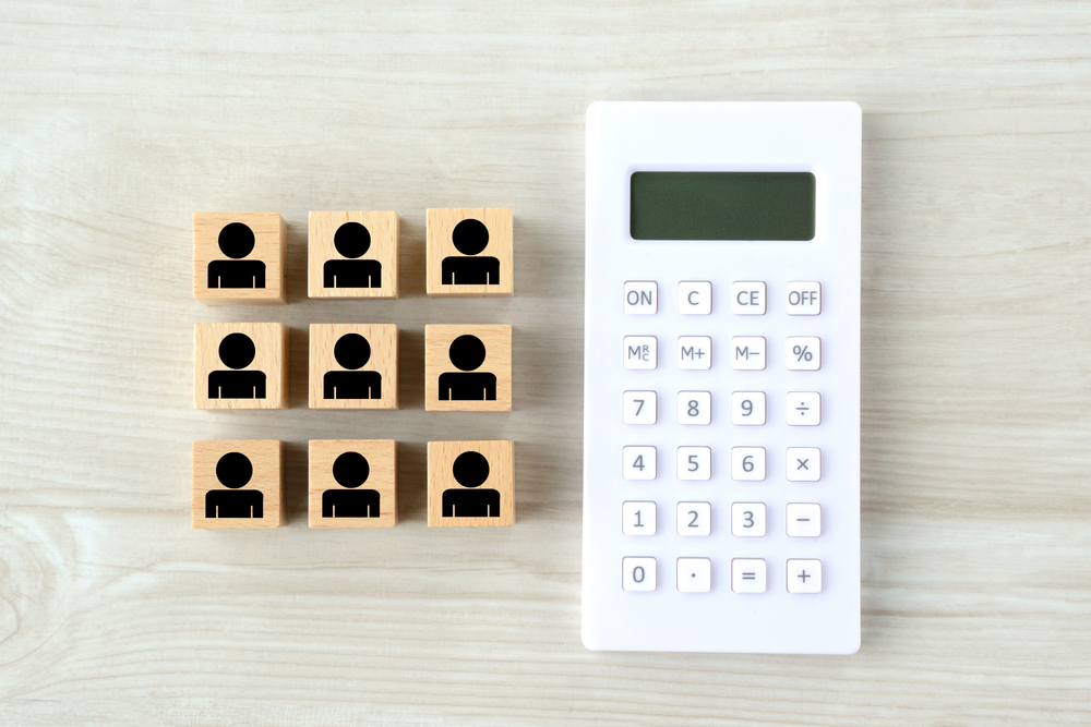 calculator and wooden blocks of people