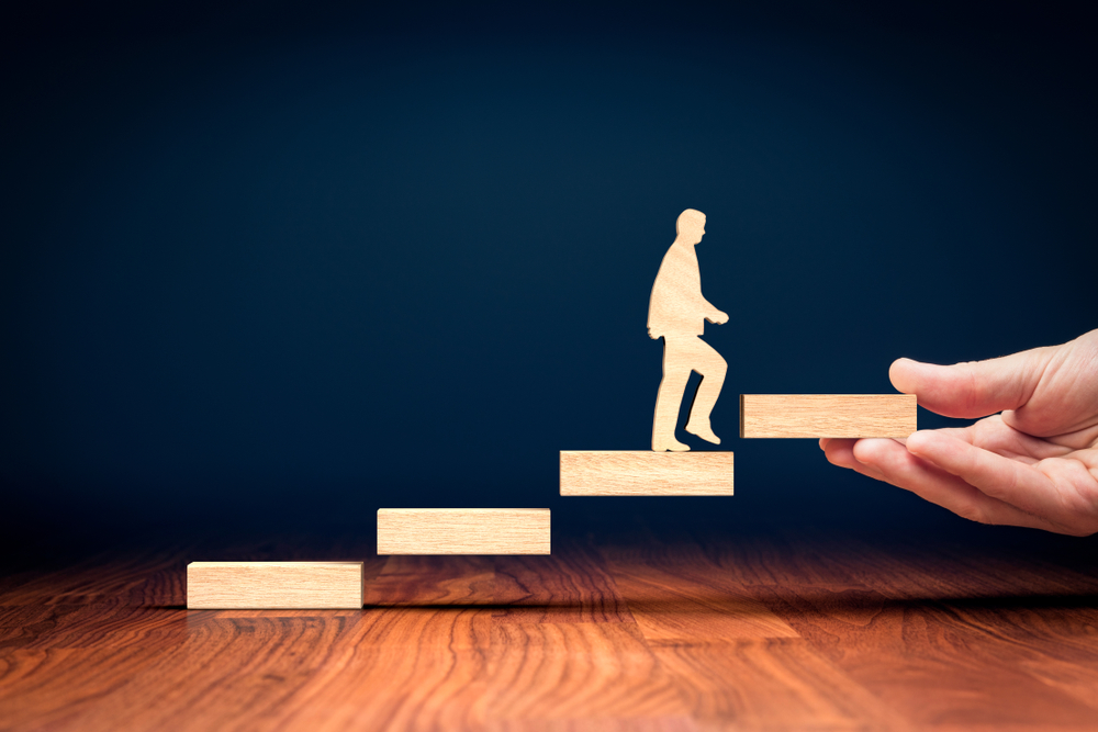 wooden person climbing on wooden steps