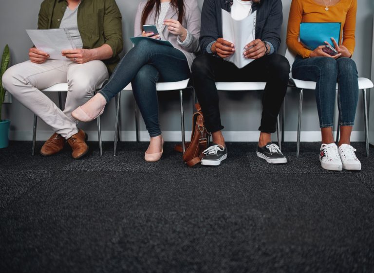 four job applicants sitting while waiting for an interview