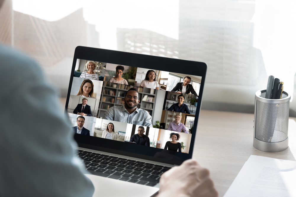 Back view of male employee have online video call on laptop with diverse multiethnic colleagues