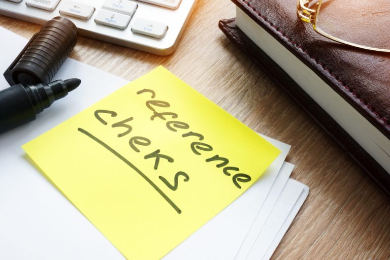 Memo stick with words Reference checks in an office table